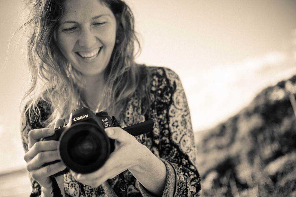 Shannon smiling as she reviews a shot on her camera